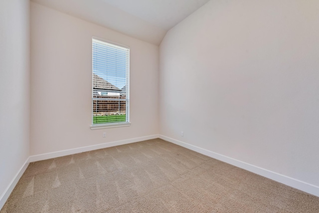 spare room featuring visible vents, light carpet, baseboards, and a lit fireplace