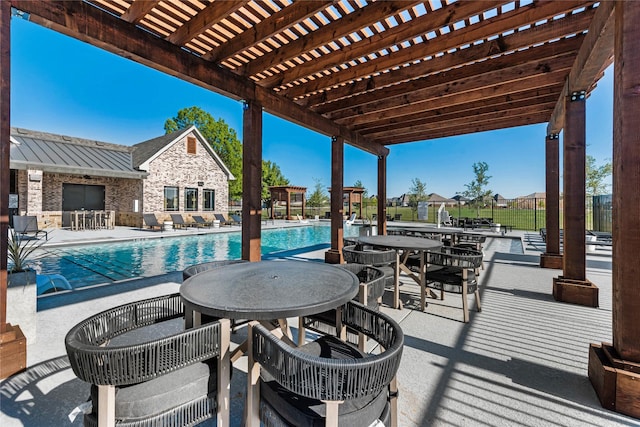 pool with a pergola, outdoor dining space, and a patio area