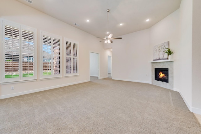 unfurnished living room featuring a tile fireplace, carpet flooring, and baseboards