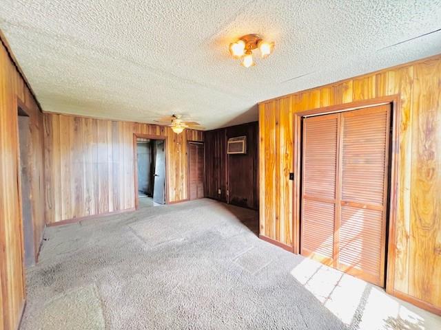 438 Atkins St, Sulphur Springs, TX 75482 - unfurnished bedroom with wooden walls, multiple closets, carpet flooring, and a textured ceiling