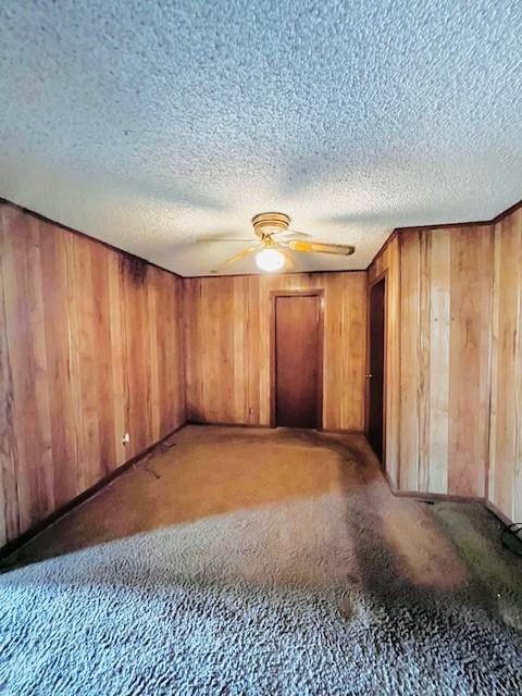 438 Atkins St, Sulphur Springs, TX 75482 - empty room featuring ceiling fan, wood walls, a textured ceiling, and carpet floors