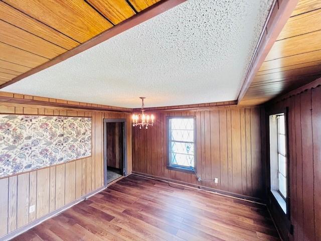 438 Atkins St, Sulphur Springs, TX 75482 - unfurnished room featuring a chandelier, wood finished floors, a textured ceiling, and wood walls