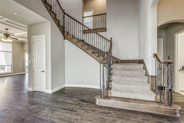 staircase featuring recessed lighting, wood finished floors, arched walkways, baseboards, and ceiling fan