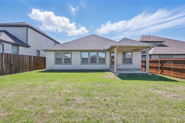 rear view of property with a patio, roof with shingles, a fenced backyard, and a lawn
