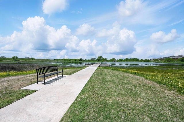 view of property's community featuring a lawn and a water view