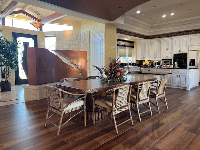 dining space featuring dark wood finished floors, recessed lighting, crown molding, and a tray ceiling