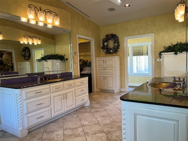 bathroom with tile patterned floors, a washtub, and vanity