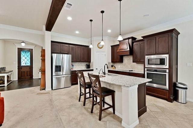 8450 Old Springtown Rd, Springtown, TX 76082 - kitchen with dark brown cabinets, a sink, arched walkways, backsplash, and appliances with stainless steel finishes