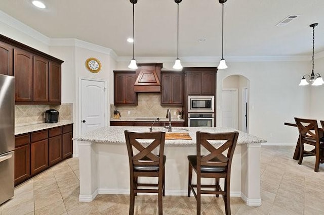 8450 Old Springtown Rd, Springtown, TX 76082 - kitchen featuring visible vents, a sink, premium range hood, arched walkways, and appliances with stainless steel finishes
