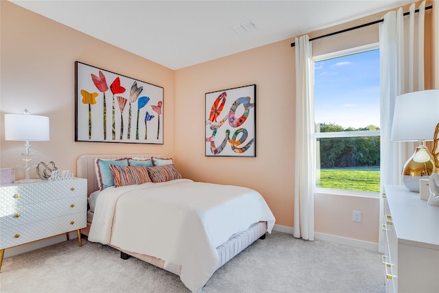 bedroom featuring visible vents, baseboards, and light carpet