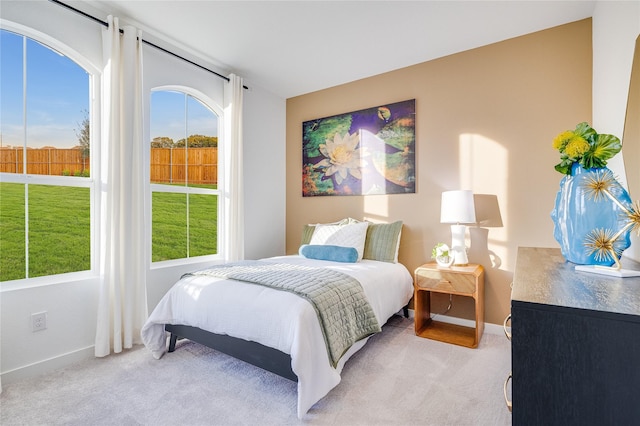 bedroom with light carpet and baseboards