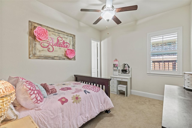 bedroom featuring light carpet, a ceiling fan, and baseboards