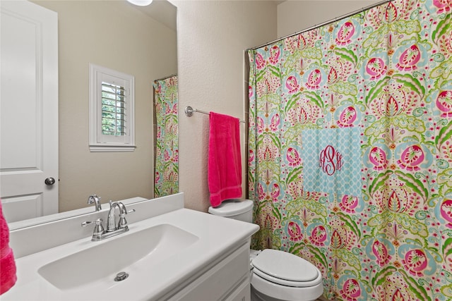 bathroom featuring a textured wall, vanity, a shower with shower curtain, and toilet