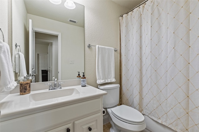 full bath featuring toilet, visible vents, a shower with shower curtain, a textured wall, and vanity