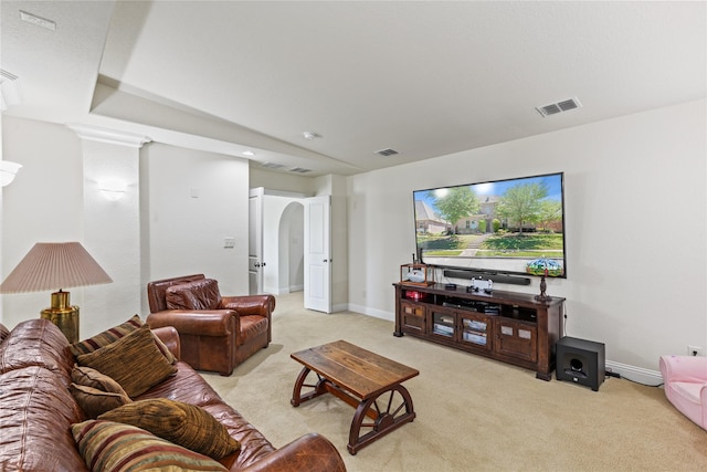 living room with light colored carpet, arched walkways, visible vents, and baseboards