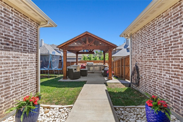 view of yard featuring a fenced backyard, a gazebo, a patio, and a trampoline