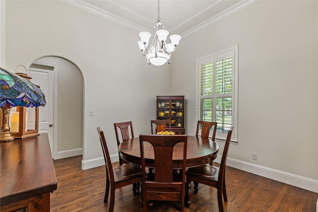 dining area featuring dark wood finished floors, baseboards, crown molding, and an inviting chandelier