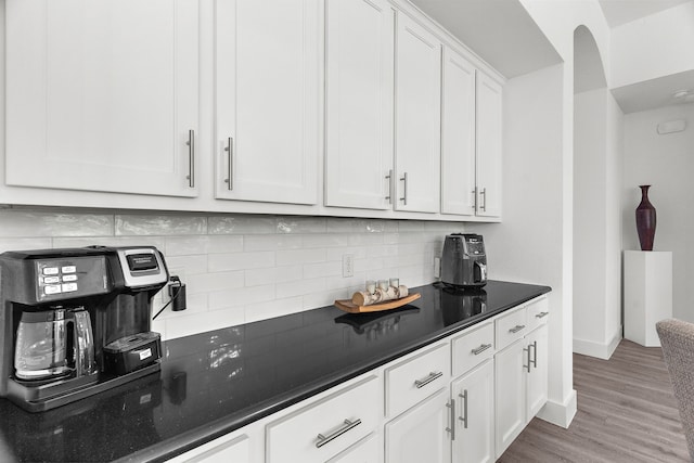 kitchen with white cabinets, baseboards, tasteful backsplash, and light wood-type flooring
