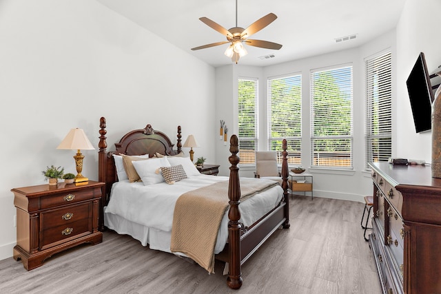 bedroom featuring visible vents, light wood finished floors, baseboards, and a ceiling fan