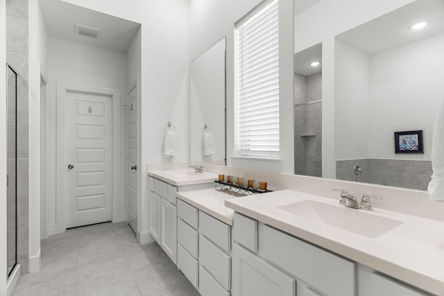 bathroom featuring a shower stall, tile patterned floors, a sink, and double vanity