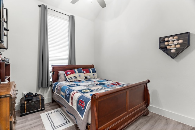 bedroom featuring baseboards, a ceiling fan, lofted ceiling, and light wood-type flooring