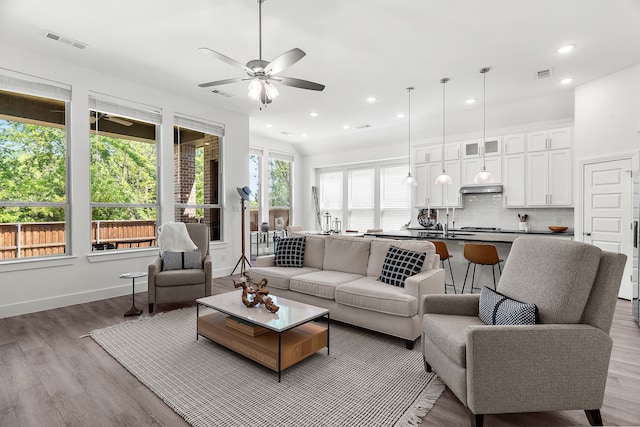 living room with recessed lighting, light wood-type flooring, visible vents, and a ceiling fan