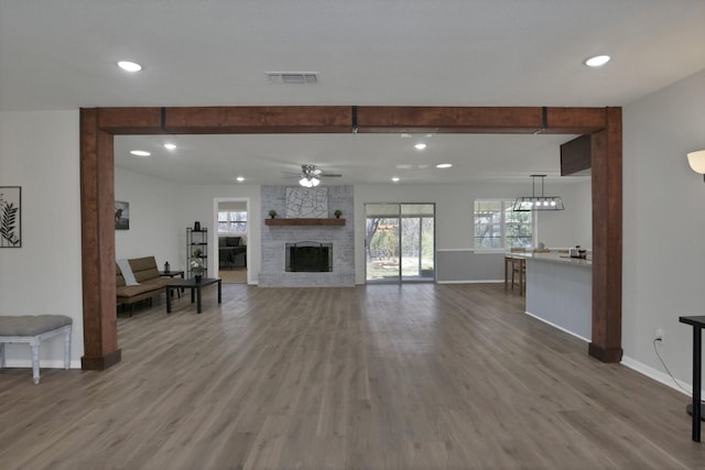 living room with a ceiling fan, baseboards, visible vents, and plenty of natural light