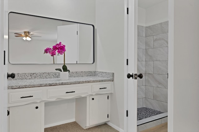bathroom featuring vanity, baseboards, ceiling fan, and a stall shower