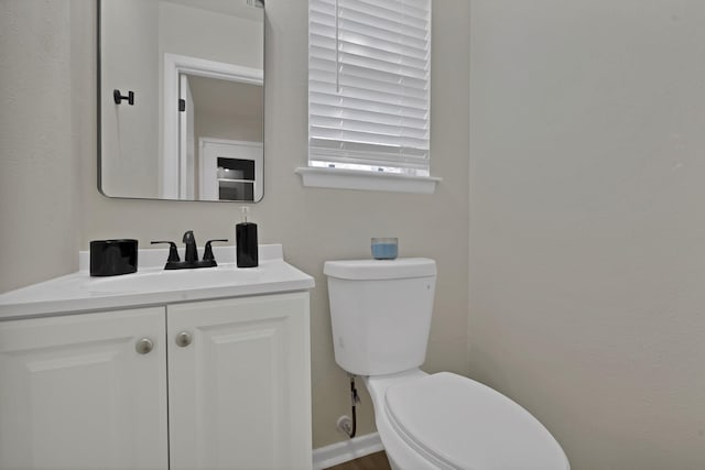 half bath featuring vanity and toilet