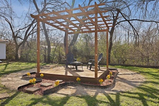 exterior space with a wooden deck, a fenced backyard, a yard, a pergola, and a fire pit