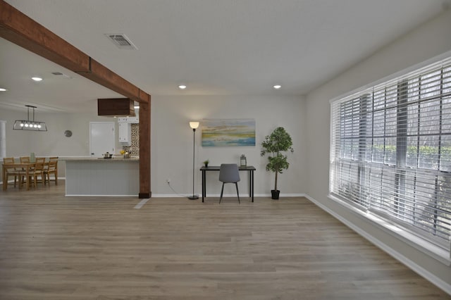 unfurnished living room featuring plenty of natural light, wood finished floors, and visible vents