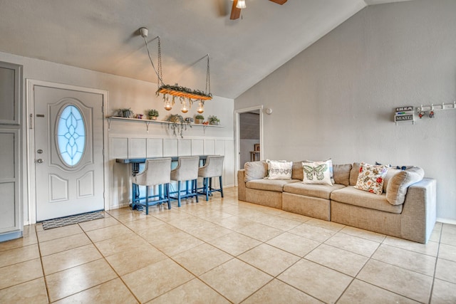 entrance foyer featuring vaulted ceiling, tile patterned flooring, a dry bar, and a ceiling fan