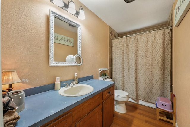 bathroom featuring toilet, a shower with curtain, vanity, and wood finished floors