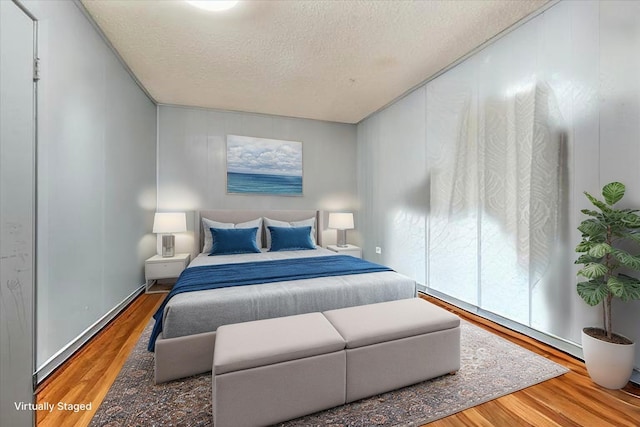 bedroom featuring wood finished floors and a textured ceiling