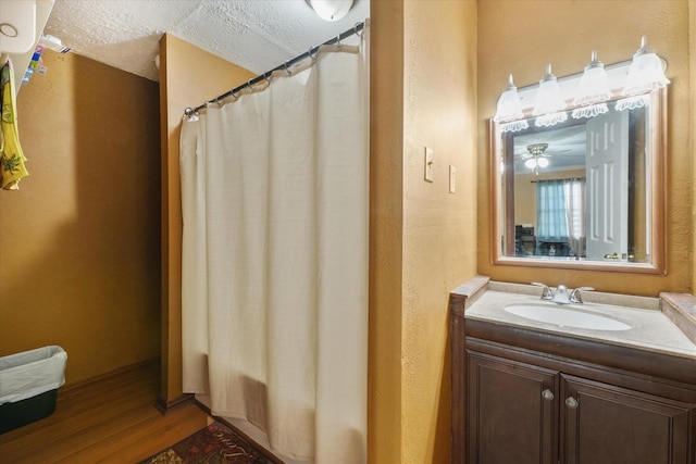 full bath with wood finished floors, a textured ceiling, and vanity