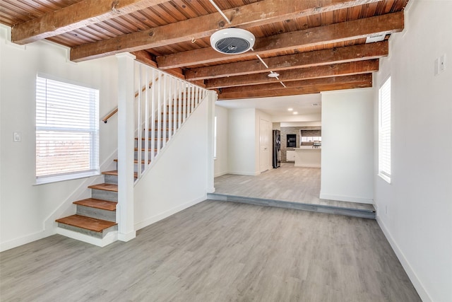 interior space with wood finished floors, fridge, wooden ceiling, and stairway