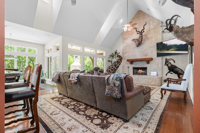 6263 Fm 934, Milford, TX 76670 - living room with a stone fireplace, wood finished floors, high vaulted ceiling, and ceiling fan