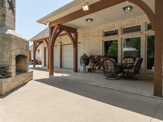6263 Fm 934, Milford, TX 76670 - view of patio featuring an outdoor stone fireplace, driveway, and a garage