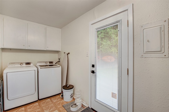 laundry area featuring separate washer and dryer, electric panel, and cabinet space
