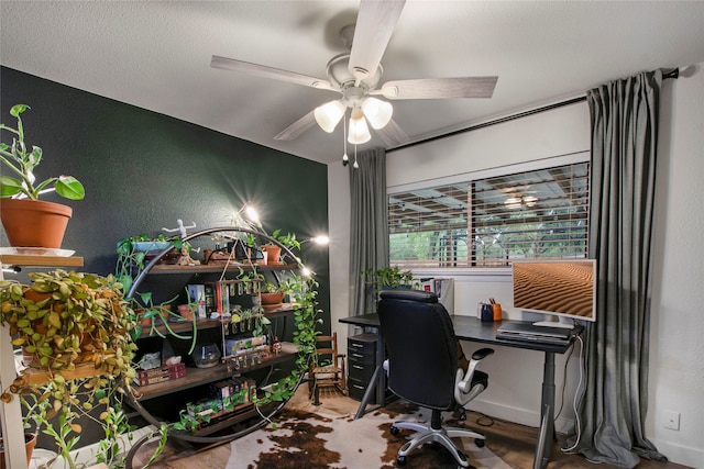 office space with a ceiling fan, baseboards, and a textured wall