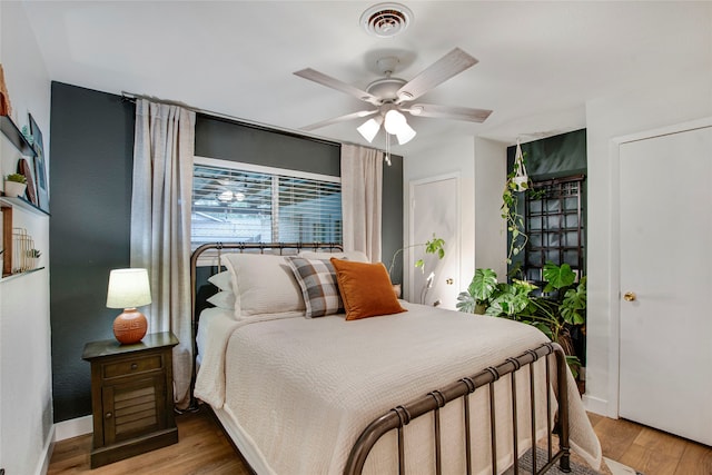 bedroom featuring visible vents, light wood finished floors, ceiling fan, and baseboards