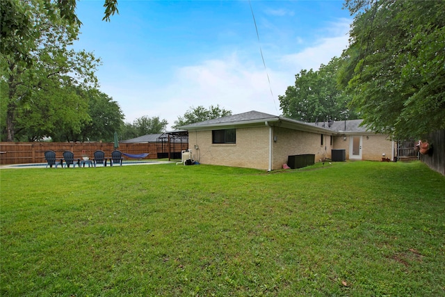 view of yard with a patio, a fenced backyard, and cooling unit