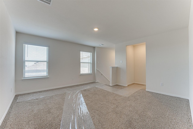 unfurnished room with visible vents, baseboards, recessed lighting, and light colored carpet