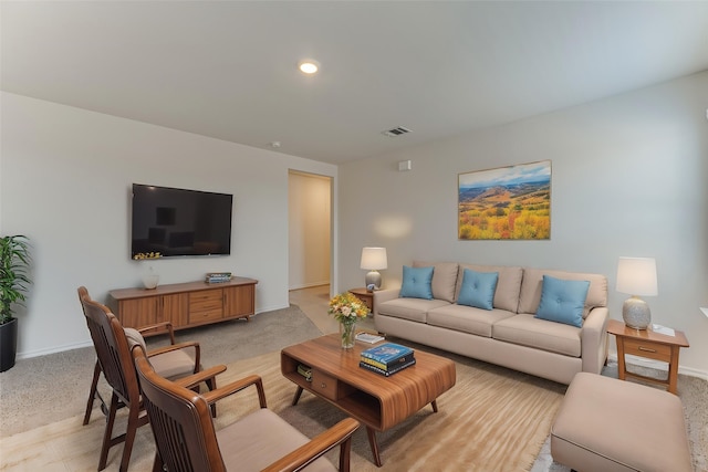 living area with visible vents, baseboards, and light carpet
