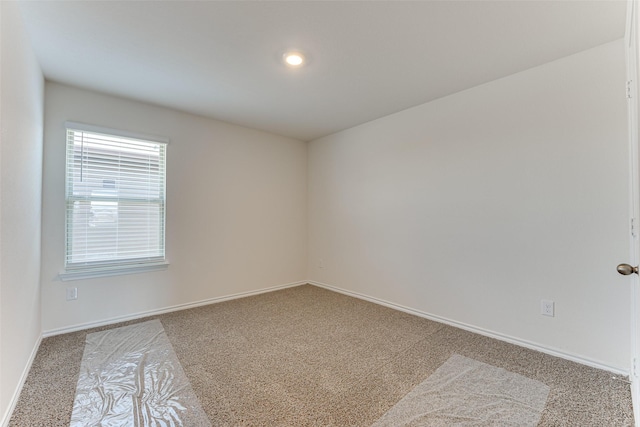 unfurnished room featuring carpet floors and baseboards