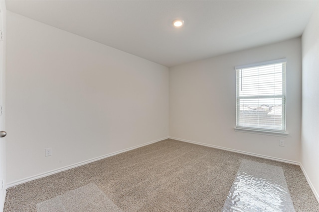 carpeted empty room with baseboards
