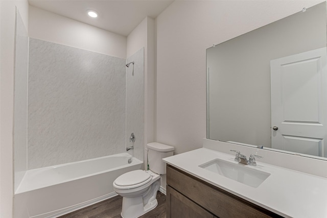 bathroom featuring wood finished floors, toilet, vanity, and shower / tub combination