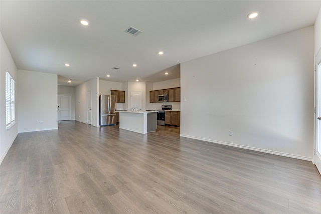 unfurnished living room featuring light wood finished floors, baseboards, visible vents, and recessed lighting