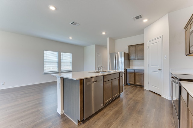 kitchen featuring dark wood finished floors, stainless steel appliances, visible vents, and a sink