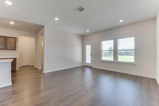 unfurnished living room featuring baseboards, visible vents, recessed lighting, and dark wood finished floors